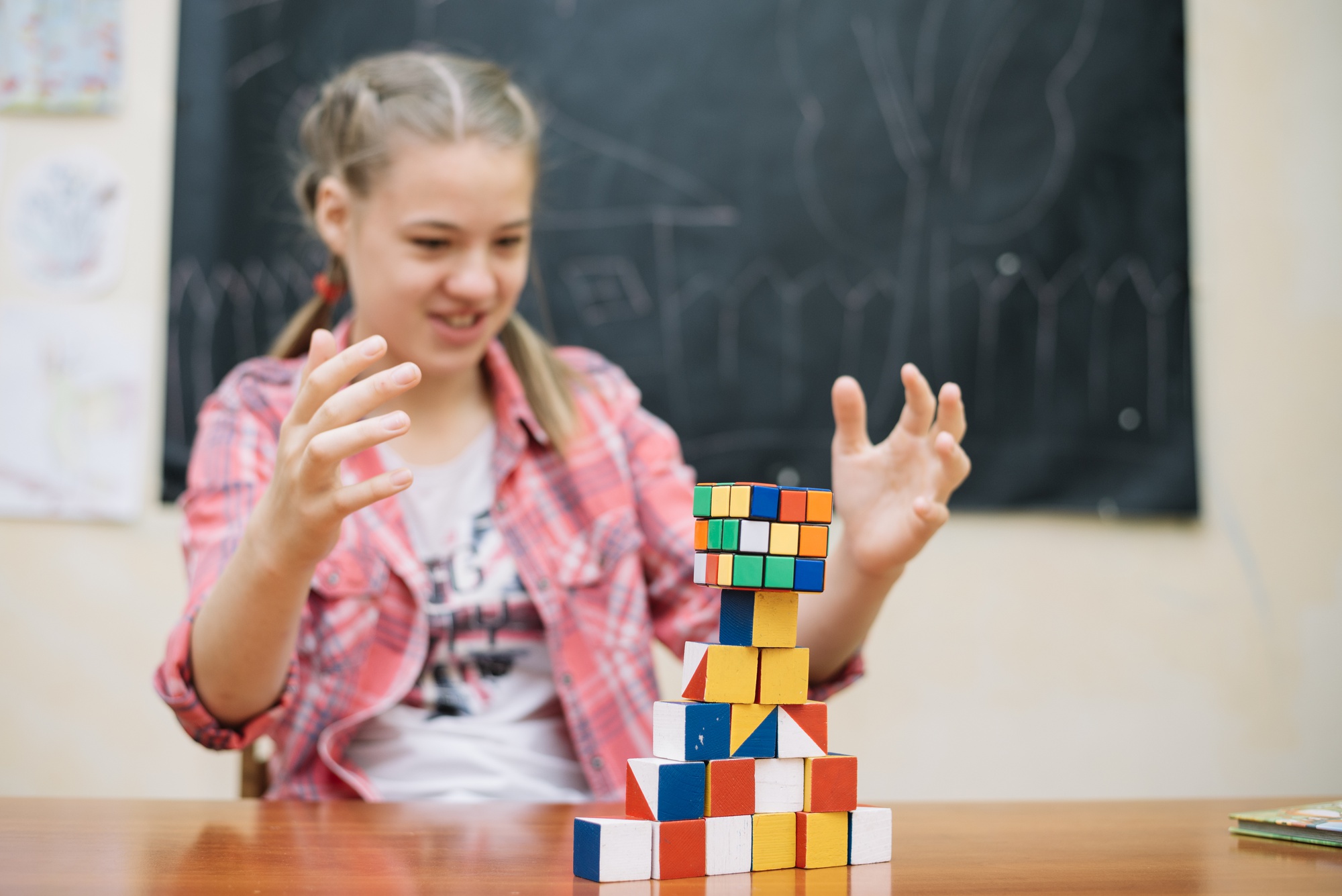 Dziecko z entuzjazmem rozwiązuje łamigłówkę matematyczną, bawiąc się klockami.