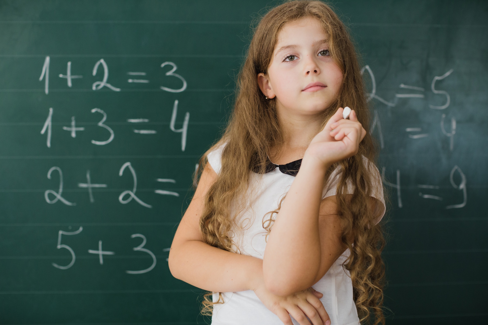 Dziecko zdezorientowane podczas nauki matematyki, z cyframi i symbolami matematycznymi wokół.